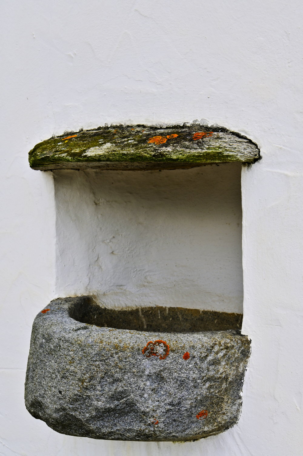 Weihwasserbecken an der nördlichen Außenwand der Kirche.